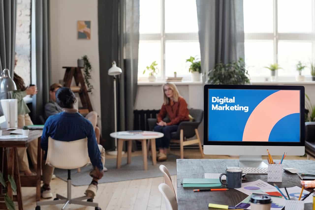 Services A diverse team engages in a digital marketing meeting in a stylish office setting.